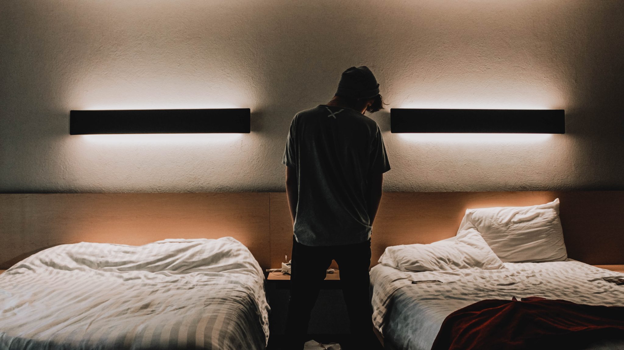 Man standing between two beds